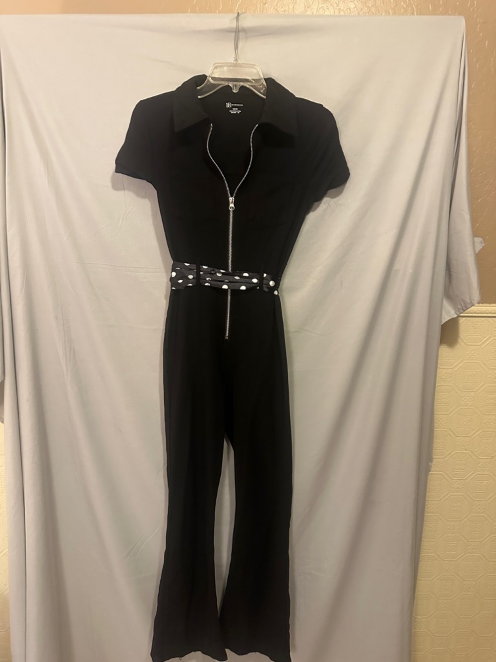 Black Short-Sleeve Zip-Front Cat Jumpsuit. Stretch bell and sleek form fit